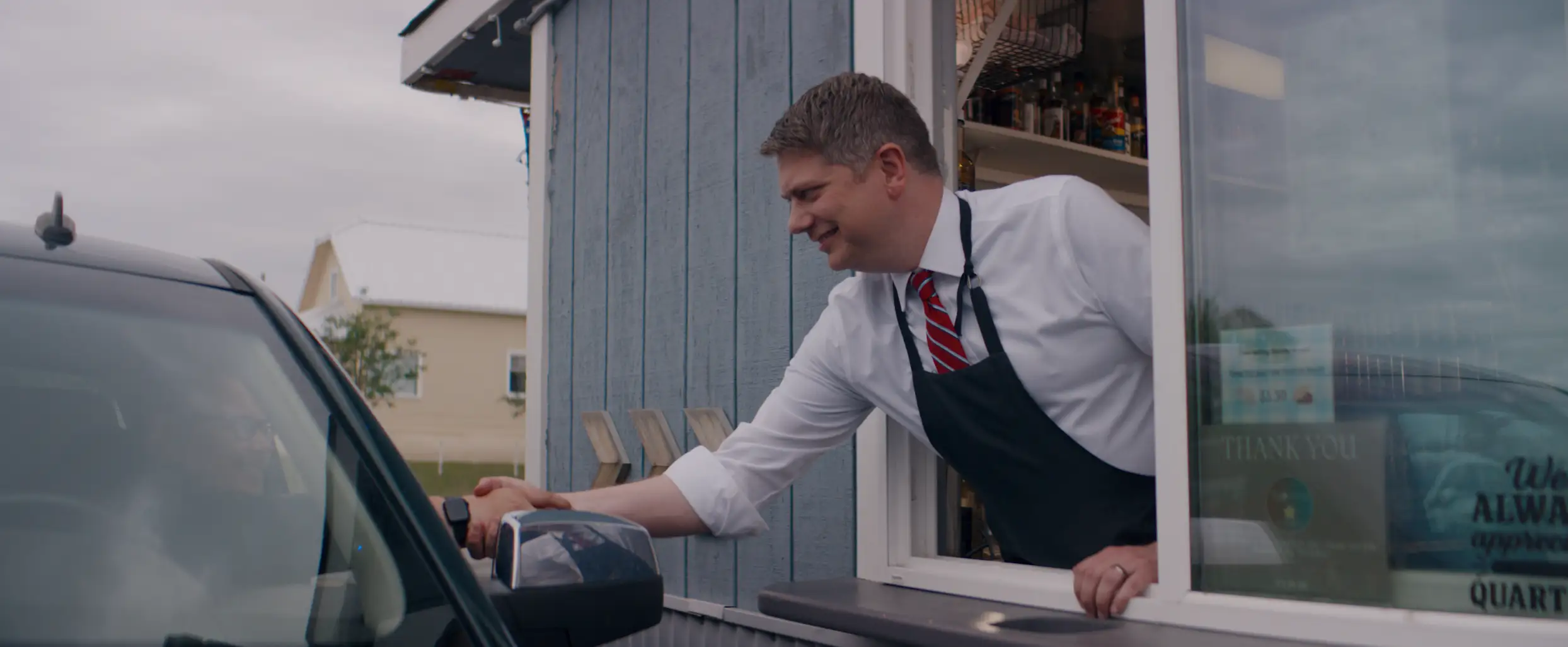 Congressman Begich serving customers from a drive-through window
